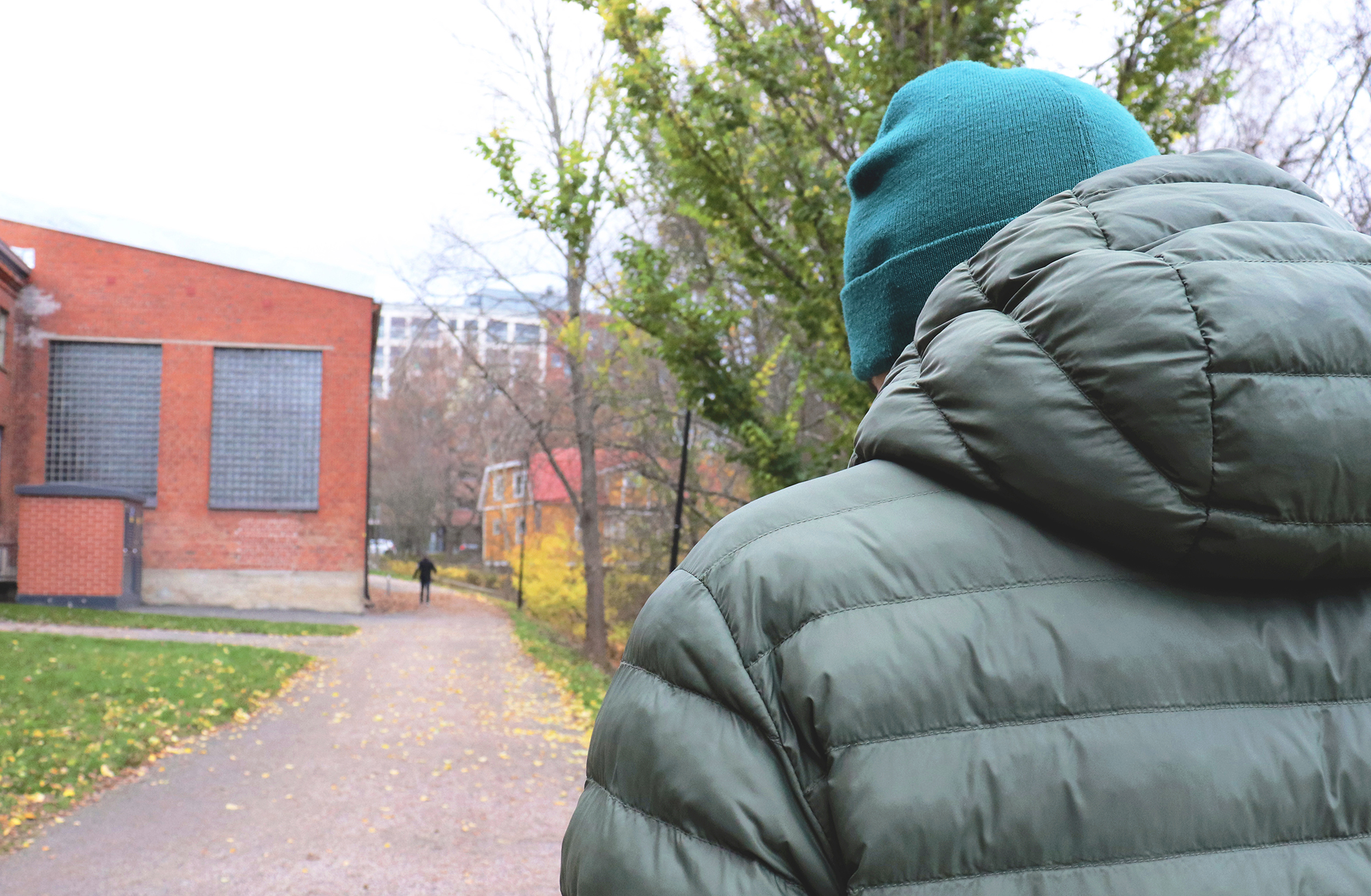 Henkilö kävelee poispäin pää painuneena. Henkilö kävelee poispäin pää painuneena.